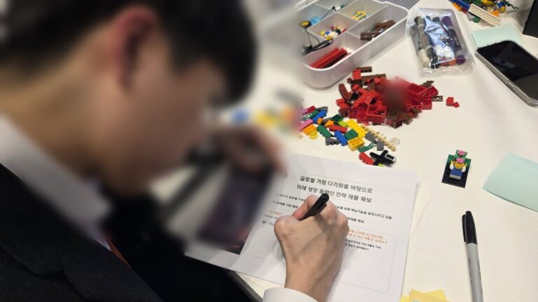 1년 후 나의 비전 목표 문장을 워크시트에 작성하는 신입사원