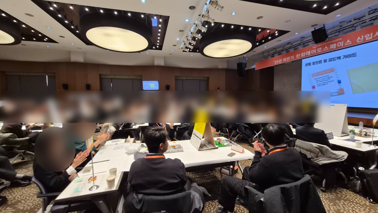 대강당에서 발표를 마친 조에게 박수를 보내는 한화에어로스페이스 신입사원들